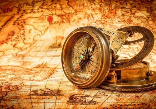 Vintage still life. Vintage compass lies on an ancient world map in 1565.